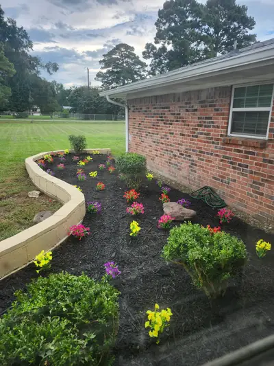 Flower garden with colorful blooms beside the brick home